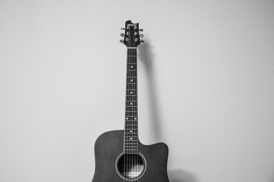Acoustic guitar against a wall